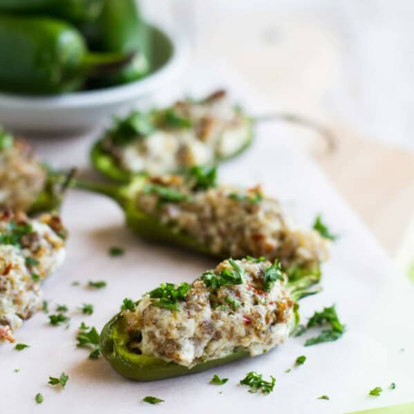 Stuffed Jalapenos with Sausage and Cream Cheese on parchment paper