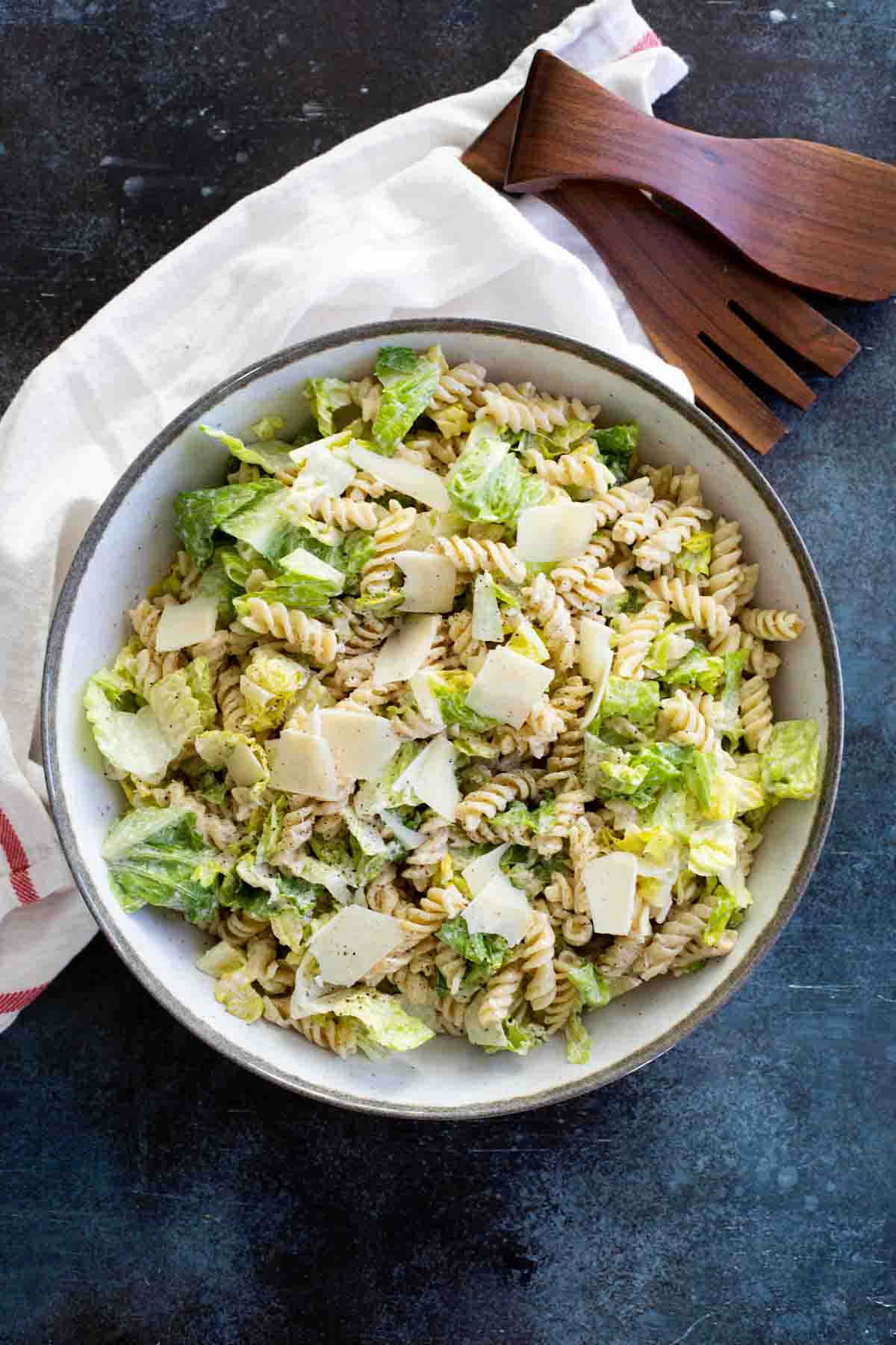 Caesar Salad with rotini pasta in a large salad bowl.