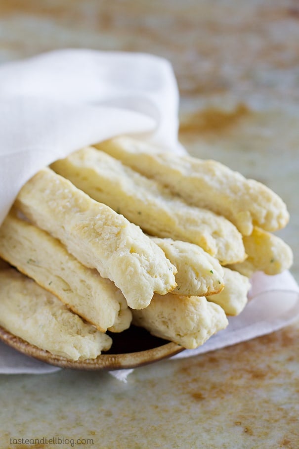 Sour Cream Breadsticks stacked and wrapped in a towel.