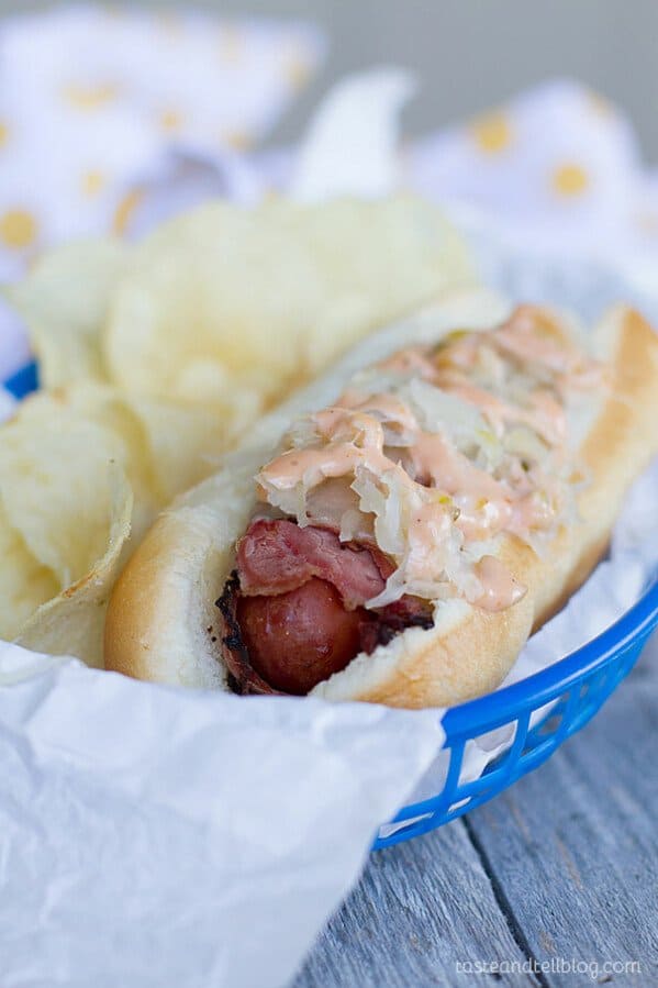 This hot dog recipe gets a reuben twist by wrapping hot dogs in pastrami then covering them in Swiss cheese, sauerkraut and a homemade Russian dressing.