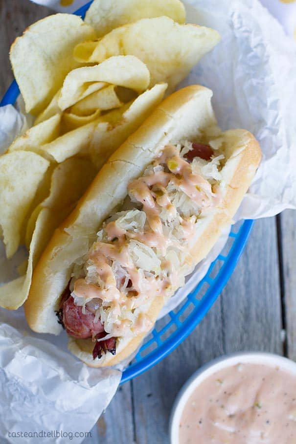 Pastrami Wrapped Hot Dog with potato chips in a basket.