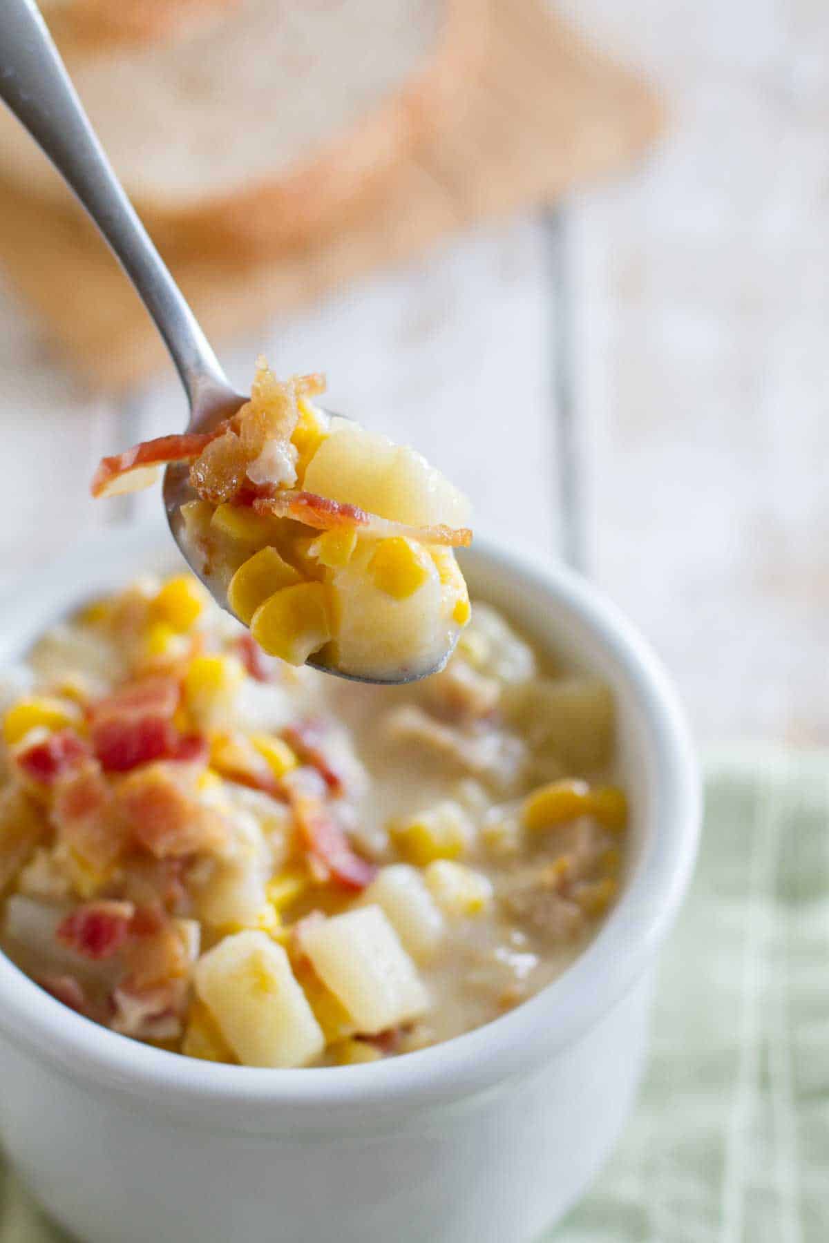 Crockpot Corn Chowder with bacon in a bowl with a spoon.