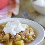 Easy Apple Crumble with Oatmeal and Coconut - Baked apples are topped with a mixture of steel cut oats and coconut in this easy apple crumble. Top it off with homemade whipped cream for an easy dessert that everyone will love.