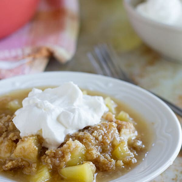 Easy Apple Crumble with Oatmeal and Coconut - Baked apples are topped with a mixture of steel cut oats and coconut in this easy apple crumble. Top it off with homemade whipped cream for an easy dessert that everyone will love.