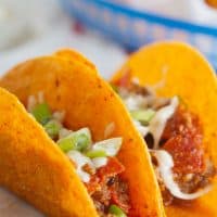 Meat Lovers Pizza Tacos - Cheesy taco shells are filled with a meaty mixture of ground beef, sausage and pepperoni with pizza sauce in these tacos that are perfect for Meat Lovers Pizza lovers.