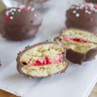 Chocolate Cherry Sandwich Cookies - Vanilla wafers are filled with a cherry cream cheese mixture, then dipped in chocolate in these fun cookies.