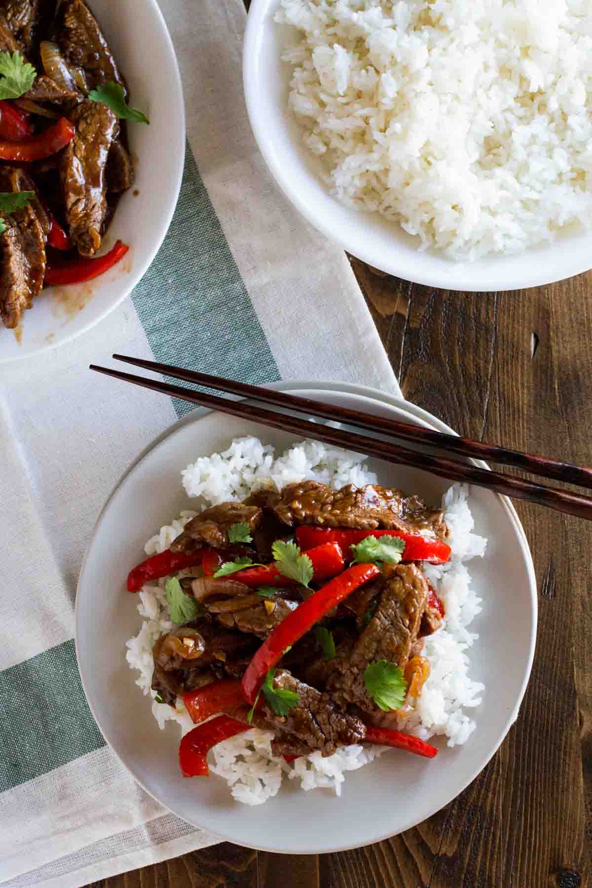Steak Stir Fry Recipe with Peppers over rice with chopsticks