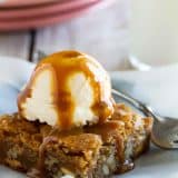 Blondie on a plate topped with ice cream and caramel