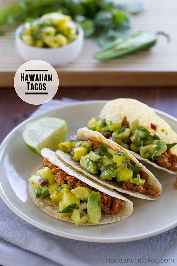 Hawaiian tacos on a plate with salsa ingredients behind