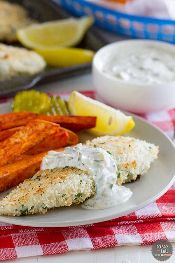 Piece of panko crusted tilapia with sauce over the top of it.