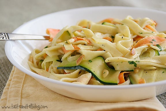 Egg noodles are served with ribbons of carrots and zucchini in a light cream sauce.