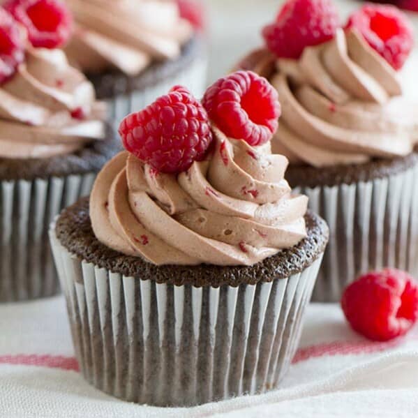 The perfect marriage of chocolate and raspberry - chocolate cupcakes are filled with a fresh raspberry filling, then topped with a silky smooth raspberry chocolate Swiss Meringue Buttercream.