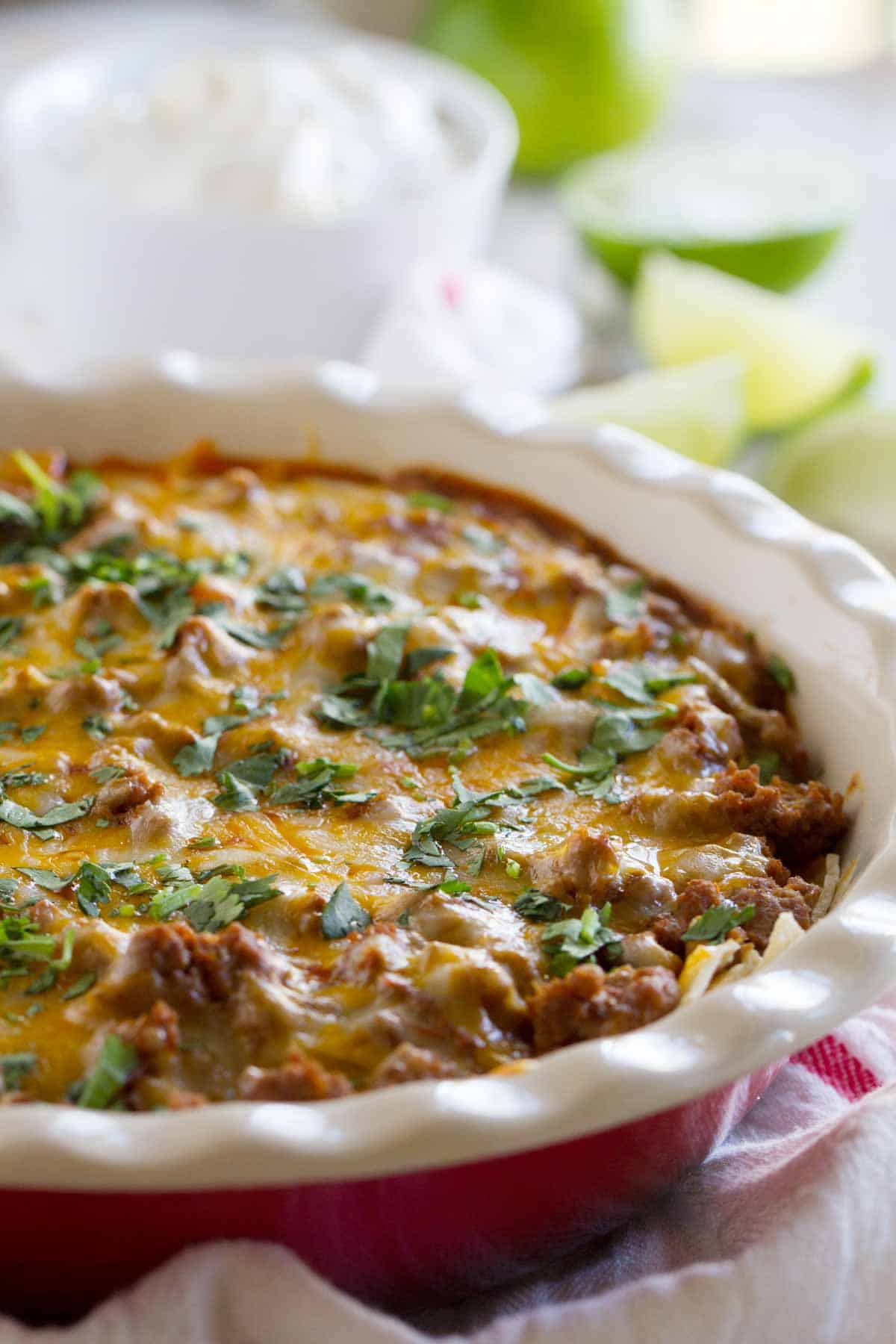Enchiladas without all the work - this Beef Enchilada Casserole recipe is family friendly and done in under 30 minutes! It's the perfect dinner for when time is short but you still want a lot of flavor. Beef Enchilada Casserole in a dish with cilantro sprinkled on top