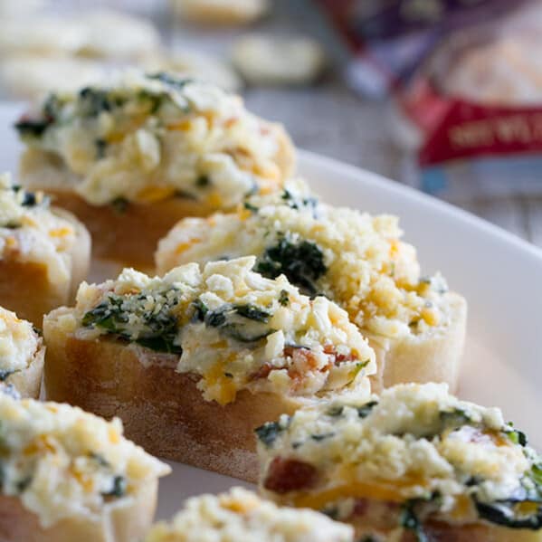 Looking for a crowd pleaser? This Cheesy Bacon and Kale Crostini Recipe is filled with tons of flavor and texture and is perfect for any party or get-together.