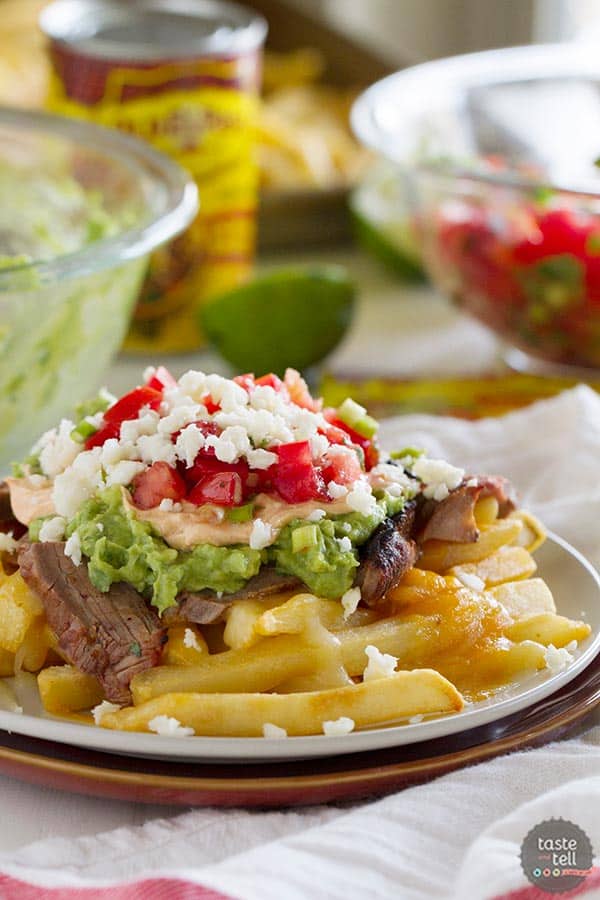 Truly indulgent, these Enchilada Steak Fries are an adaptation of the popular San Diego treat - Carne Asada Fries.  French fries get topped with steak, guacamole, sour cream and pico de gallo for the perfect southern California dish.