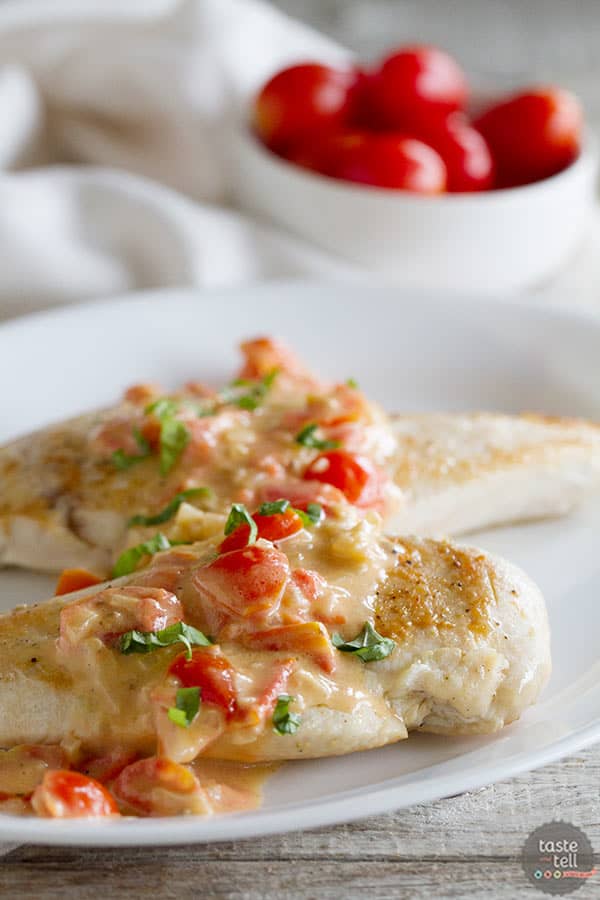 Pan seared chicken breasts are topped with a creamy tomato parmesan sauce that is made in the same pan for an easy weeknight dinner.