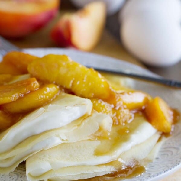 crepes filled with a cream cheese mixture and topped with sauteed peaches