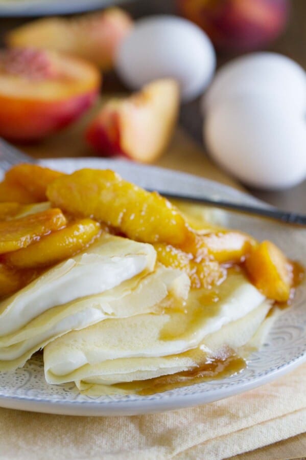 crepes filled with a cream cheese mixture and topped with sauteed peaches