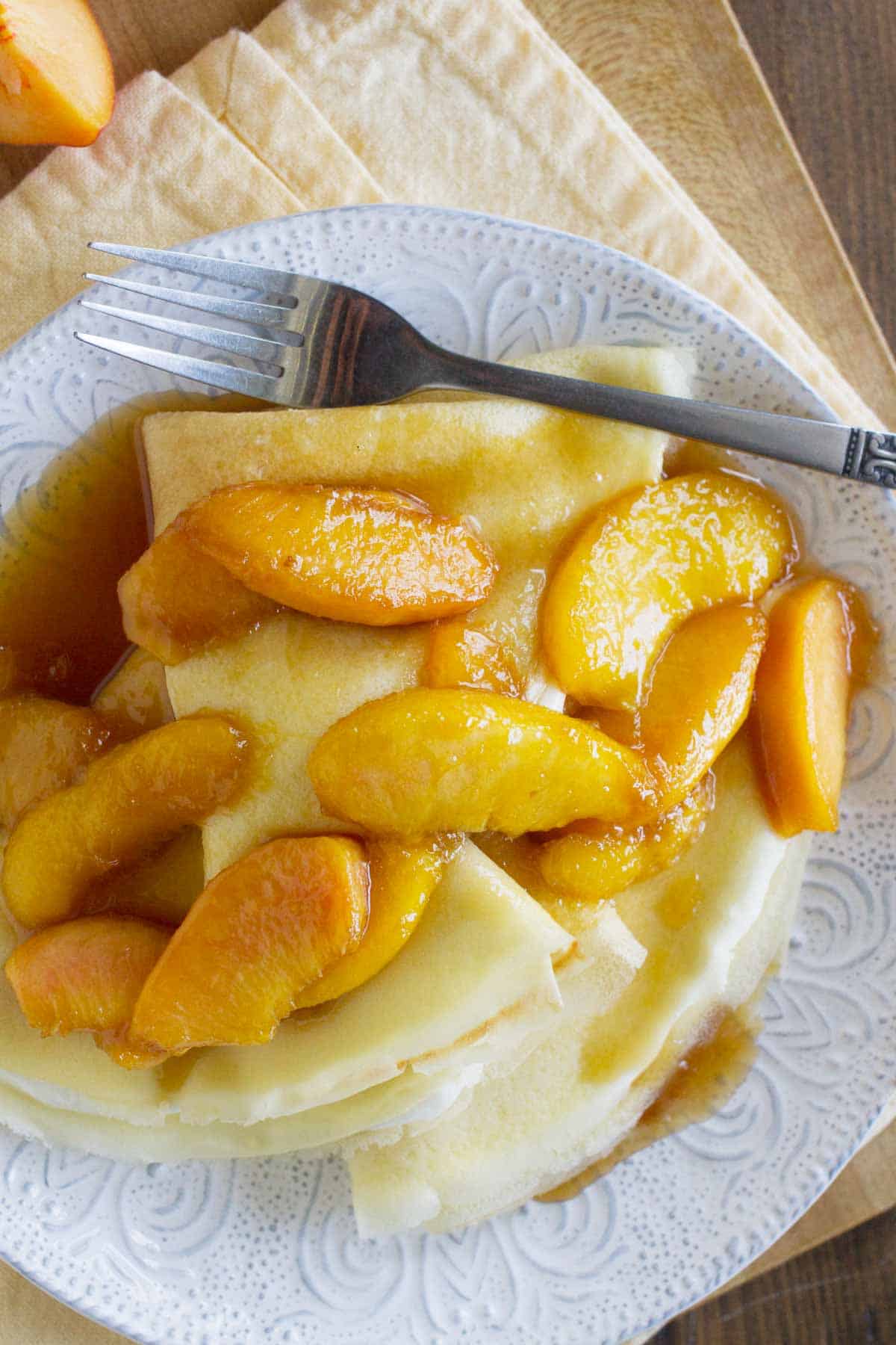 Sweet Crepes topped with Peaches on a plate