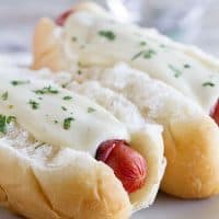 Cordon Bleu Hot Dogs topped with creamy cheese sauce.