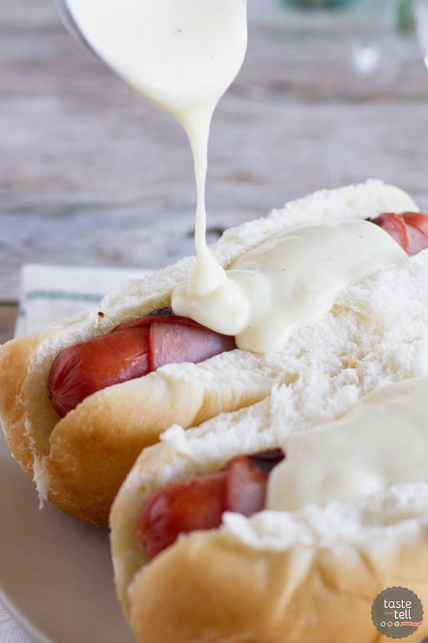 pouring sauce onto cordon bleu hot dogs.