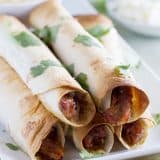 Pork gets slow cooked in a sweet and spicy sauce and then turned into an easy dinner with these Slow Cooker Sweet Pork Baked Taquitos.