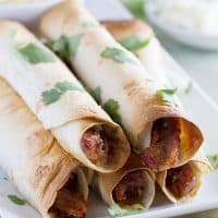 Pork gets slow cooked in a sweet and spicy sauce and then turned into an easy dinner with these Slow Cooker Sweet Pork Baked Taquitos.