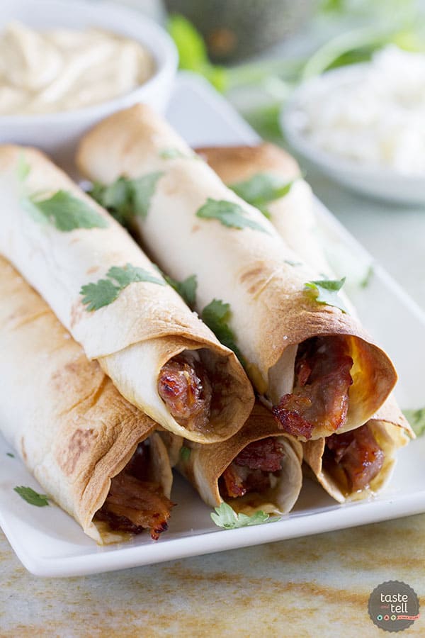 Pork gets slow cooked in a sweet and spicy sauce and then turned into an easy dinner with these Slow Cooker Sweet Pork Baked Taquitos.