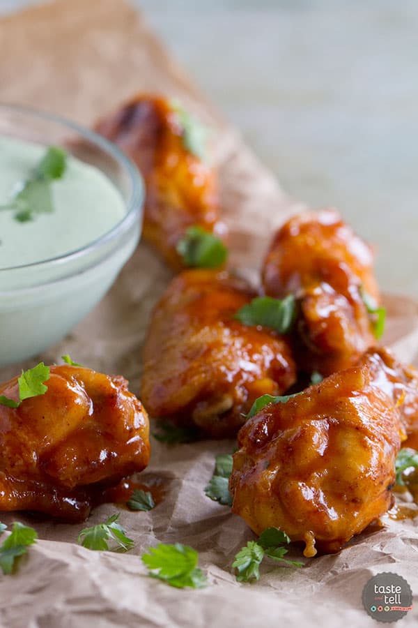 This Enchilada Chicken Wing Recipe takes wings that have been pan fried and bathes them in a slightly spicy enchilada sauce - a great Tex-Mex take on game day food!