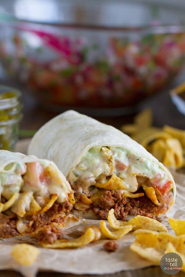 The ultimate Tex-Mex burrito - this Frito Pie Burrito is filled with chili, green chile queso, pico de gallo, avocado cream and jalapenos, all wrapped up in a tortilla.