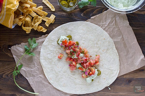 Adding Pico de Gallo to a tortilla.