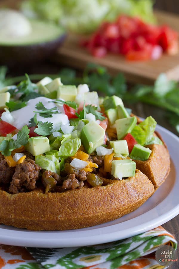 Waffles are not just for breakfast! These savory Taco Cornbread Waffles are topped with ground beef taco mixture and all of your favorite taco toppings. This is a great way to change up taco night!