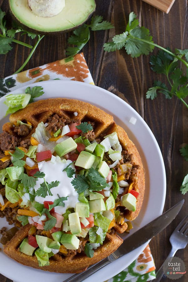 Waffles are not just for breakfast! These savory Taco Cornbread Waffles are topped with ground beef taco mixture and all of your favorite taco toppings. This is a great way to change up taco night!