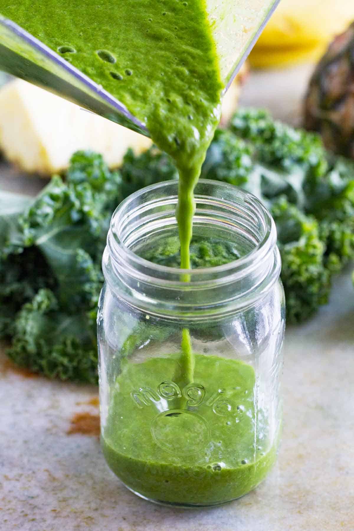 pouring kale smoothie into a jar