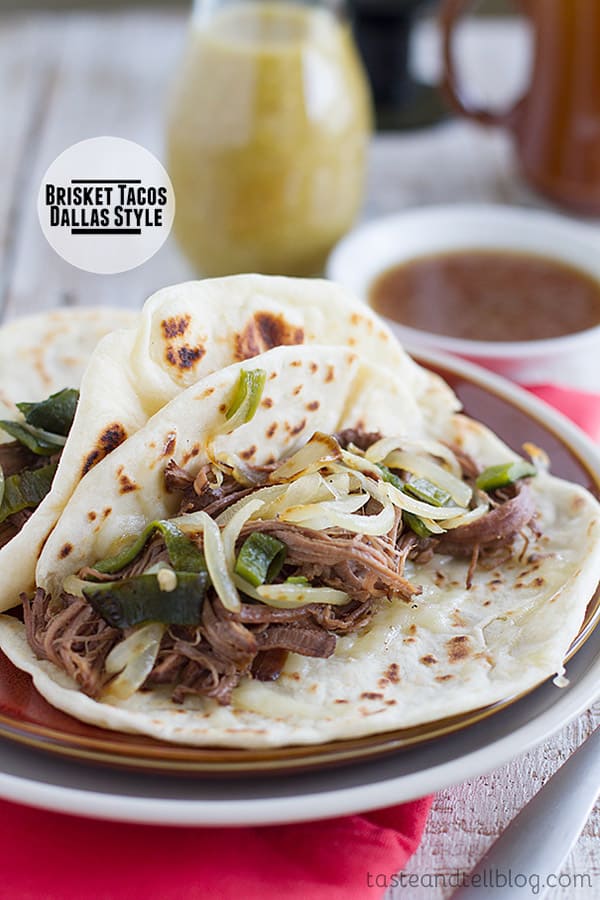 Beef Brisket is slow cooked and served on tortillas with cheese and sautéed onions and peppers, then served alongside the pan juices for dipping in these Brisket Tacos, Dallas Style.