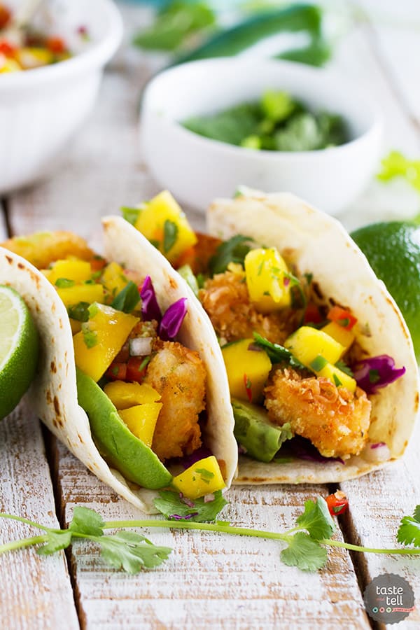 Crispy coconut crusted shrimp are topped with a sweet and spicy mango salsa in this Coconut Shrimp Taco Recipe that brings a taste of the tropics to taco night!