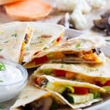 A great way to get your veggies in, these Roasted Veggie Quesadillas are a great way to clean out the veggie drawer to make a lunch or dinner that won’t leave you missing the meat!
