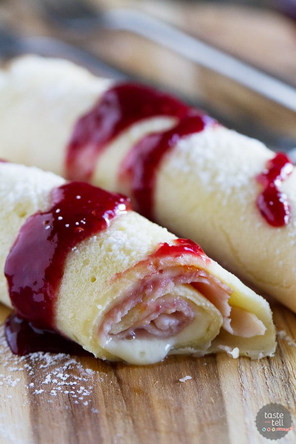 These Monte Cristo Crepes are sweet and savory and perfect for breakfast, brunch or dinner! Tender crepes are filled with cheese, ham and turkey and topped with raspberry jam and powdered sugar.