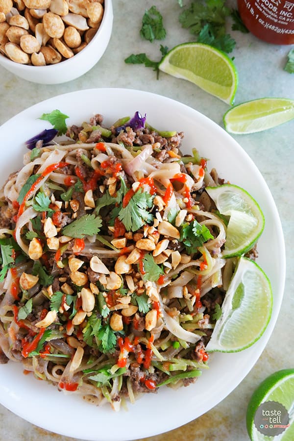 noodles topped with beef, cilantro, peanuts, and lime slices.