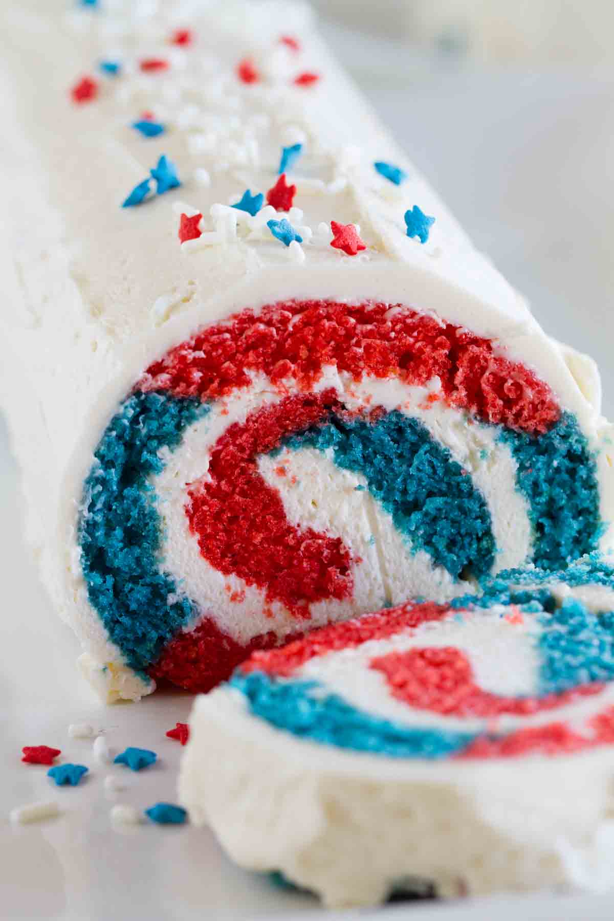red white and blue cake roll with star sprinkles cut showing interior