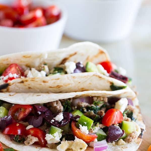 These Greek Tacos are anything but boring - filled with ground turkey with spinach and topped with hummus, feta, and lots of veggies. Give your Taco Tuesday some excitement!