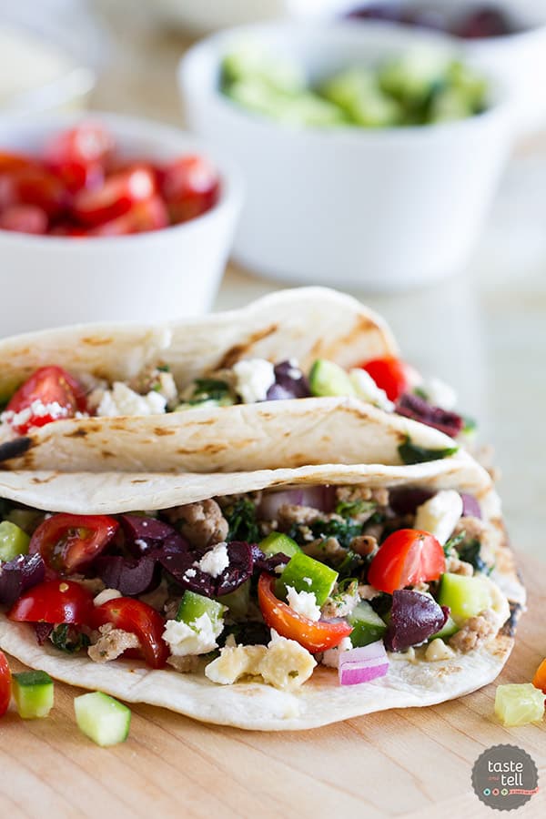 These Greek Tacos are anything but boring - filled with ground turkey with spinach and topped with hummus, feta, and lots of veggies. Give your Taco Tuesday some excitement!