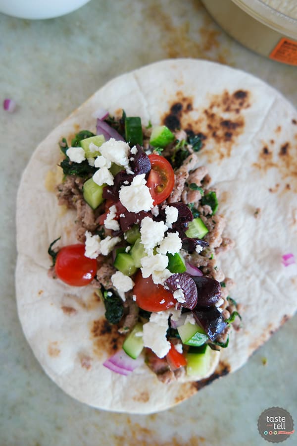 These Greek Tacos are anything but boring - filled with ground turkey with spinach and topped with hummus, feta, and lots of veggies. Give your Taco Tuesday some excitement!