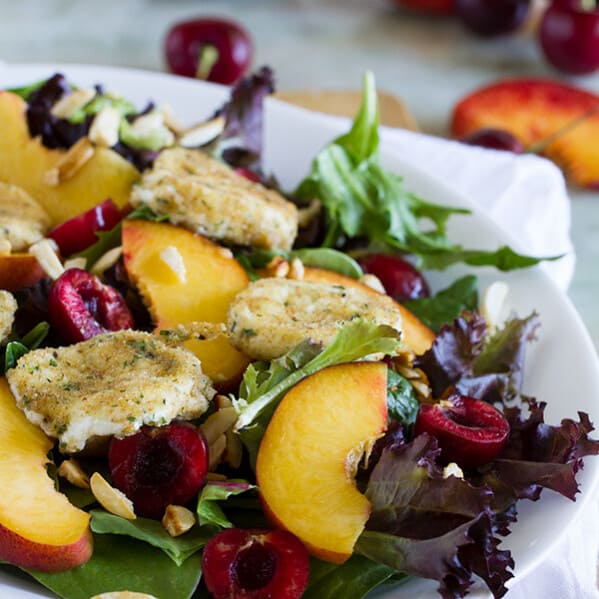 salad topped with stone fruits and fried goat cheese.