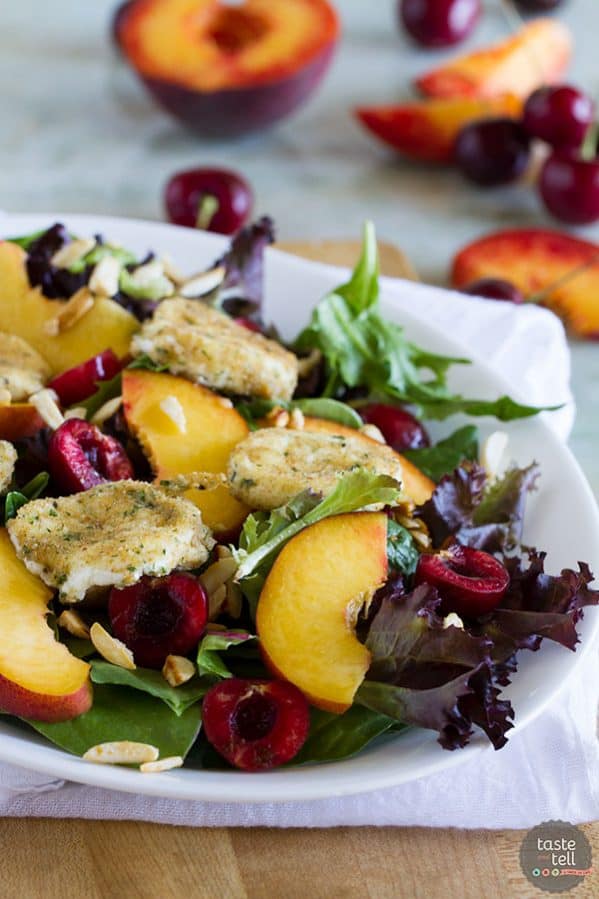 salad topped with stone fruits and fried goat cheese.