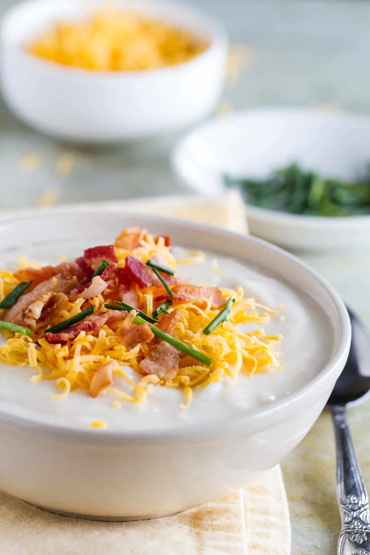 Crockpot Potato Soup topped with cheese, bacon and chives