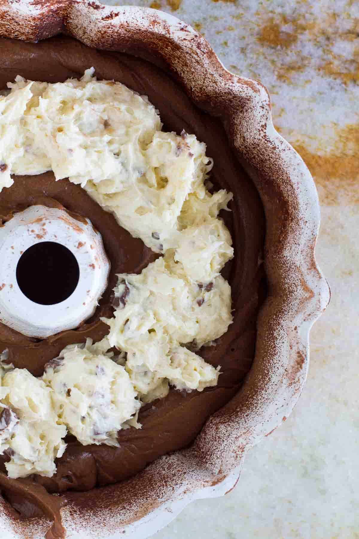 chocolate batter in a bundt cake pan with almond joy filling