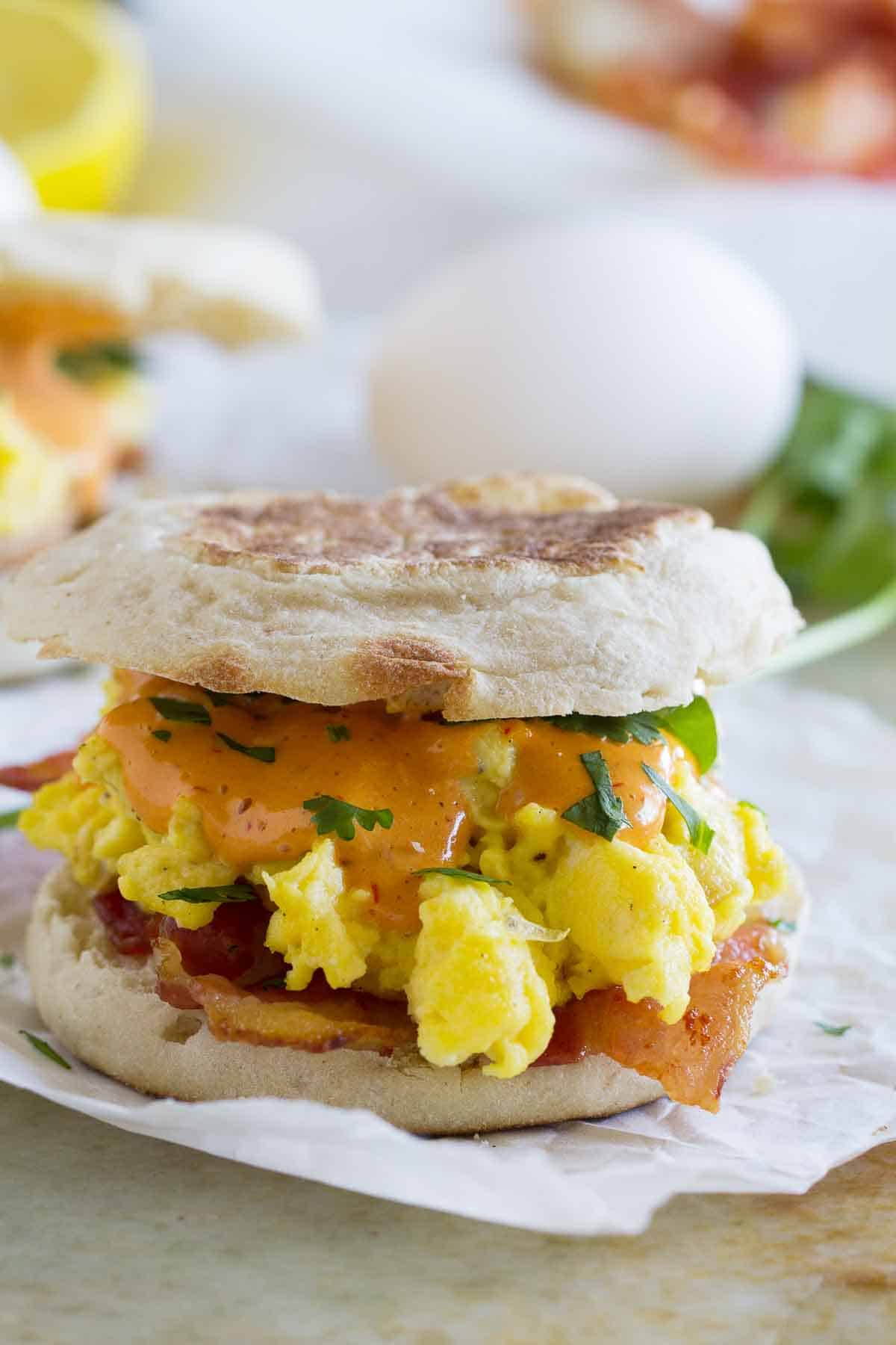 Bacon and Eggs Benedict Sandwich with ingredients in the background
