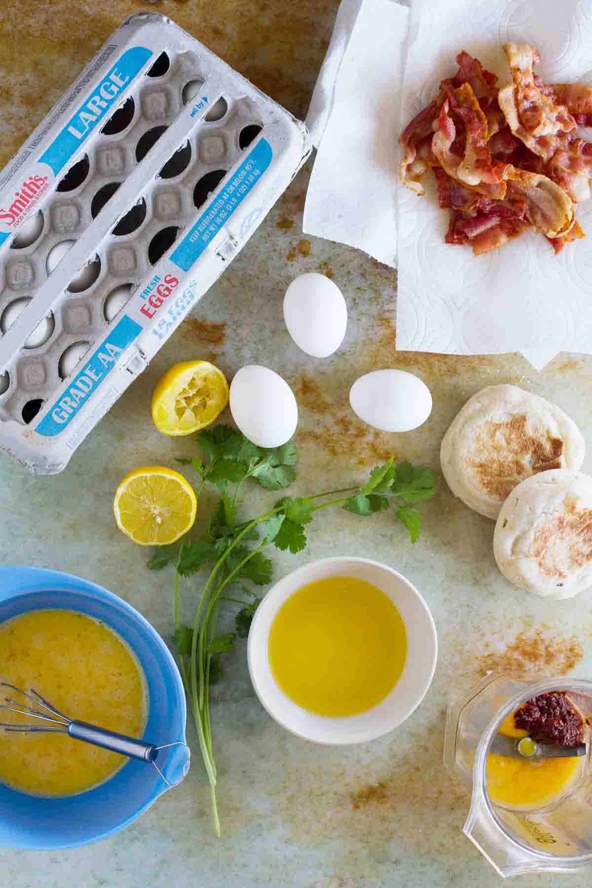 overhead view of ingredients needed to make Bacon and Eggs Benedict Sandwich