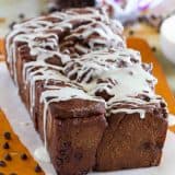 Loaf of chocolate pull apart bread drizzled with icing.